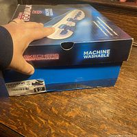 Skechers shoe box showing branding and machine washable feature with size label indicating women's size 12 US