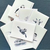 Photo showing a collection of folded white note cards with animal watercolor illustrations from the Menagerie Collection by Thistle House Co.