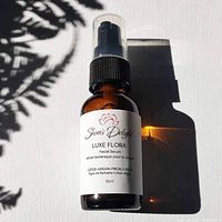 Photo of amber glass 30ml bottle of Luxe Flora Facial Serum by Shiva's Delight with black pump and white label.