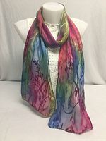 Full view of the hand dyed scarf displayed on a white mannequin bust. Shows multicolor gradient from pink to blue with botanical branch designs.