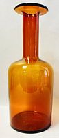 Front view of amber Holmegaard Gulvase studio glass vase showing cylindrical body and narrow neck with flared dark-edged rim.