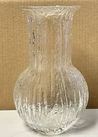 Front view of the clear textured blown glass vase, showing the bulbous body and narrow, flared neck.