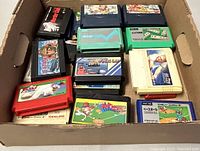 Box holding all 21 vintage Japanese Famicom cartridges showing varied colors and artwork on labels.