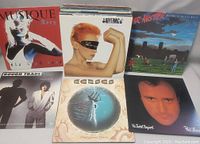 Six LPs laid out in two rows showing Musique, Eurythmics, Mr. Mister, Rough Trade, Kansas and Phil Collins covers