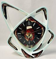 Front view of the ceramic atomic starburst clock showing the Formenton label, glazed finish, and overall shape and color.