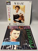Photo of Wham! The Video VHS tape in original white sleeve with Japanese text and photo of George Michael and Andrew Ridgeley. Also shows the Culture Club Profile booklet featuring Boy George on the cover.