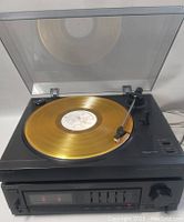 Sony PS-LX285 turntable on top of the TA-AX295 amplifier playing a gold-colored vinyl record with dust cover opened to show tonearm and controls.