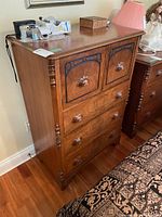 Full view of the McLagan wood dresser showing carved drawer fronts and turned side columns.