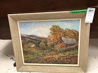 Framed oil on board painting showing colorful fall trees and rural houses in a landscape.