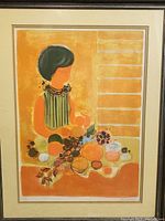 Full view of framed lithograph showing a faceless woman with dark hair, sitting with various fruits and vegetables on a table in vibrant warm tones.