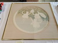 Framed circular intaglio artwork showing stylized hanging fuchsia flowers in muted tones, signed by the artist, with mat and gold frame