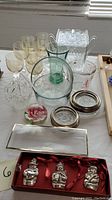 Full lot overview showing glass bowls, measuring cups, ornaments, paperweight, and glasses.