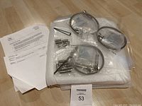 Photo shows all components of the AS Hanging Systems Tension Display including two wire columns, three acrylic sleeves, metal mounting hardware, instruction sheets, in original packaging foam.