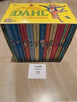 Photo of the closed box set showing colorful book spines and the yellow decorated box top.