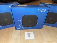 Three ZTE Rocket Hub MF279T units in blue retail boxes on table, two boxes sealed, one box unopened.