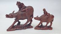 Front view of both Chinese hardwood carvings showing water buffalo and riders