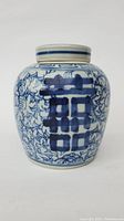Front view of blue and white porcelain jar with floral and Chinese character design