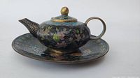 Front view of teapot on matching plate