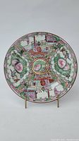 Front view of the Famille Rose porcelain plate showing detailed figure and floral decorations in pink, green, and multi-color enamel.