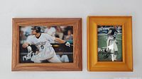 Two framed autographed sports photos, one of Matt Holliday batting in Rockies uniform, the other a football player in dark uniform.