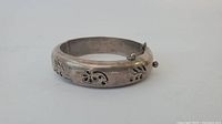 Front view of the sterling silver hinged bangle bracelet showing floral etching.