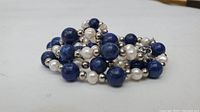 Close-up view of the pearl and lapis lazuli bead bracelet with silver-toned round spacer beads