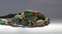 Close-up of necklace beads showing turquoise and wood beads with natural color variations.