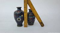 Both cloisonne vases standing with rulers showing approximate height, against white background.