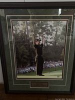 Front view of framed photo showing Mike Weir with raised golf club celebrating Masters win with signature on photo.