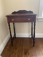 Full view of antique wooden writing table with a single drawer and turned legs