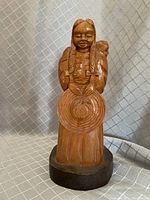 Front view of the Mexican mother with child wood carving on a circular wooden base, showing detailed carving and polished finish.
