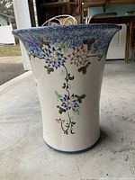 Front angle of large ceramic vase showing floral design and flared rim
