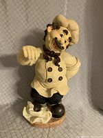Front view of the chef figurine showing detailed face, hat, chef attire, and base.