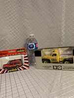 Photo showing both boxed model vehicles side by side with a water bottle for scale.