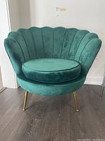 Front view showing scallop back, round seat cushion, gold legs