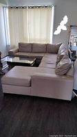 Full view of cream leather sectional couch assembled in an L-shape in living room area.