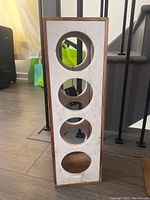Stone and wood wine rack showing four circular bottle holders on the front stone panel.