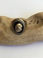 Front view of men's gilt silver and onyx eagle ring with detailed eagle head on black onyx oval mount.