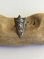 Front view of the antique silver shield ring showing detailed raised rose and leaf design