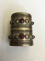 Front view of wide silver cuff bracelet showing arrangement of red carnelian stones and detailed engraved patterns.