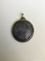 Front view of round pendant showing agate bullseye stone set in twisted rope silver frame