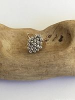 Top view of the vintage gold ring showing the white sapphire cluster in an oval floral shape.
