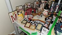 Wide shot of various Christmas decorations including wooden signs, snowman figurines, star decoration, and rolling pin.