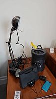 Photo showing two adjustable black desk lamps, Honeywell space heater,and Sony docking station radio with iPod on a wooden table.