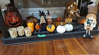 Full lot showing a variety of Halloween and fall-themed decor including pumpkins, candle holders, scarecrows, and a ghost figure.