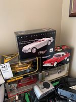 Five boxed die-cast model cars stacked showing front and side images of boxes and models inside, including 1953 Corvette, 1934 Ford Coupe, and others
