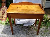 Front view of the rectangular pine table showing the wood surface with knots and raised back edge.