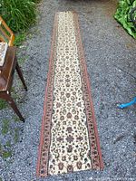 Full length view of long hall runner rug laid out on gravel