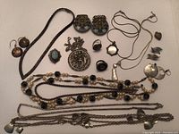 Full overview of the jewelry lot including necklaces, bracelets, earrings, pins, rings, pendants, and chains
