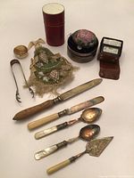 Full view of all items showing variety including cutlery, small containers, fabric bag, and analog meter.